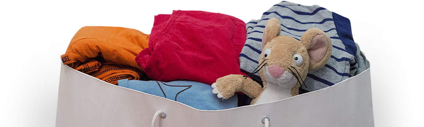 A bundle of clothes spilling from a bag with a cuddly mouse looking out over the edge.